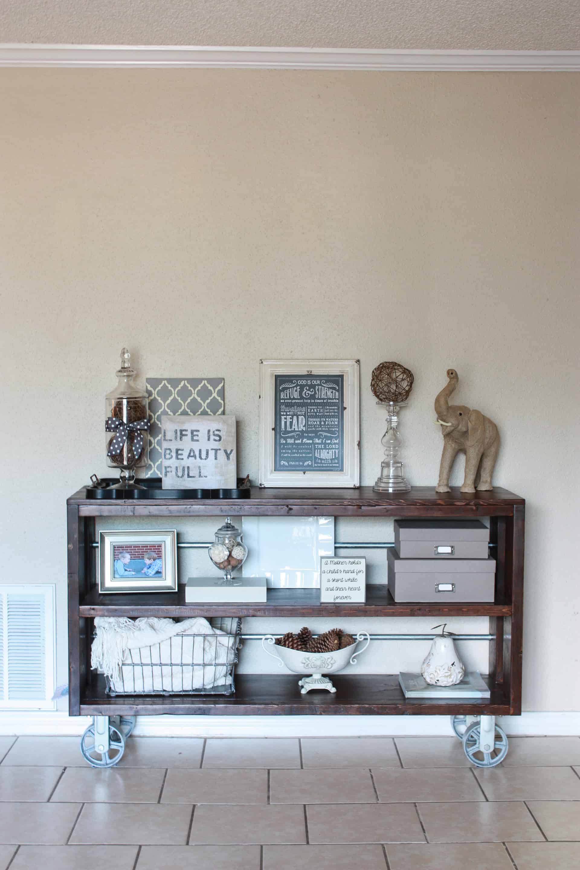 DIY wood and steel console table with white and gray decorative stuff on it