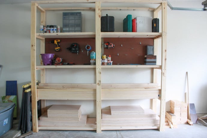 DIY garage storage shelves with some tools, wood and boxes on them