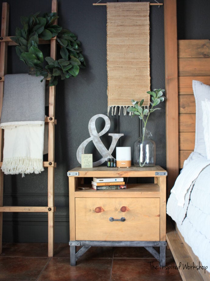 DIY Nightstand with a blanket ladder to the left and a wood bed to the right decorations on top