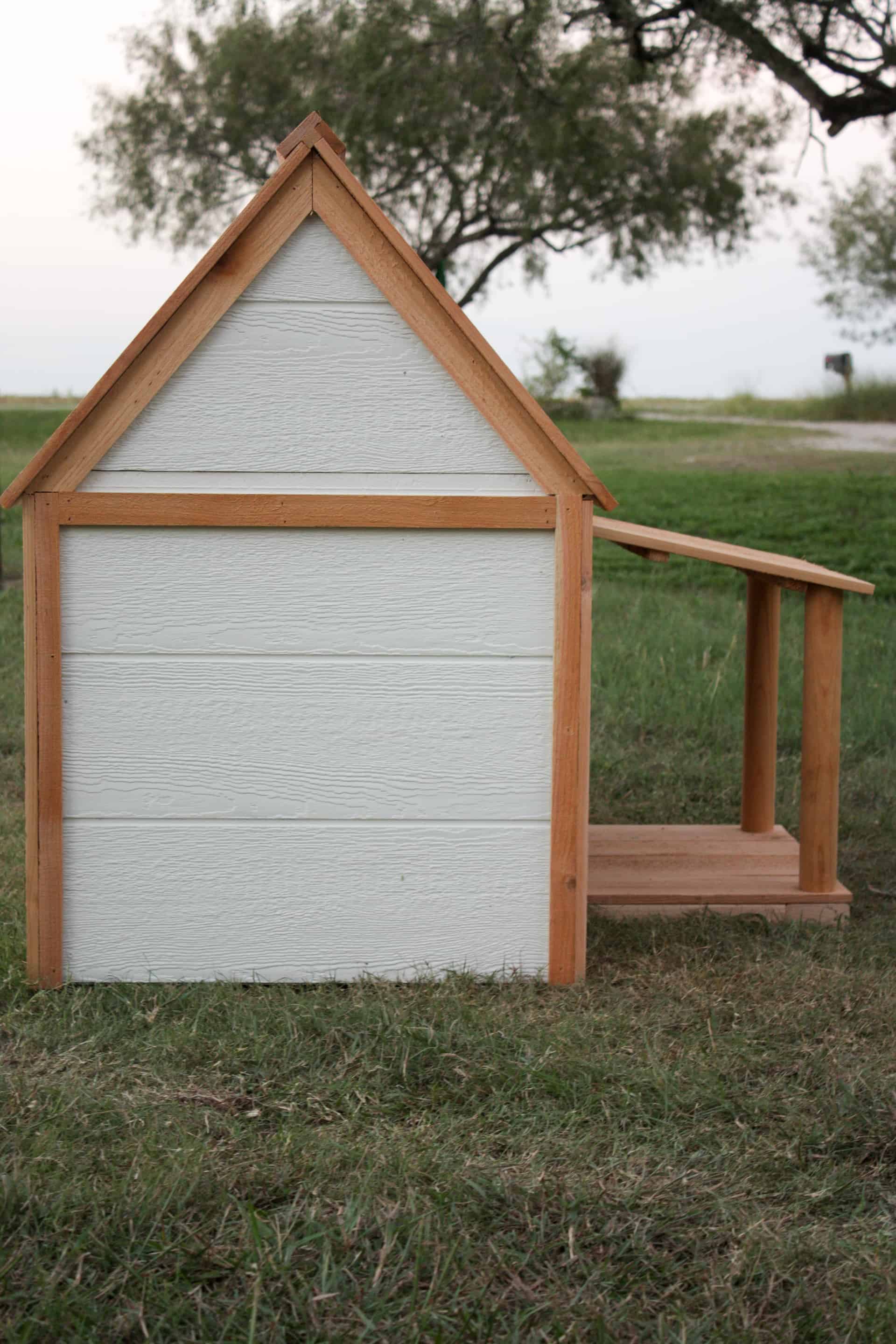 Doghouse with Porch side view of white and cedar doghouse