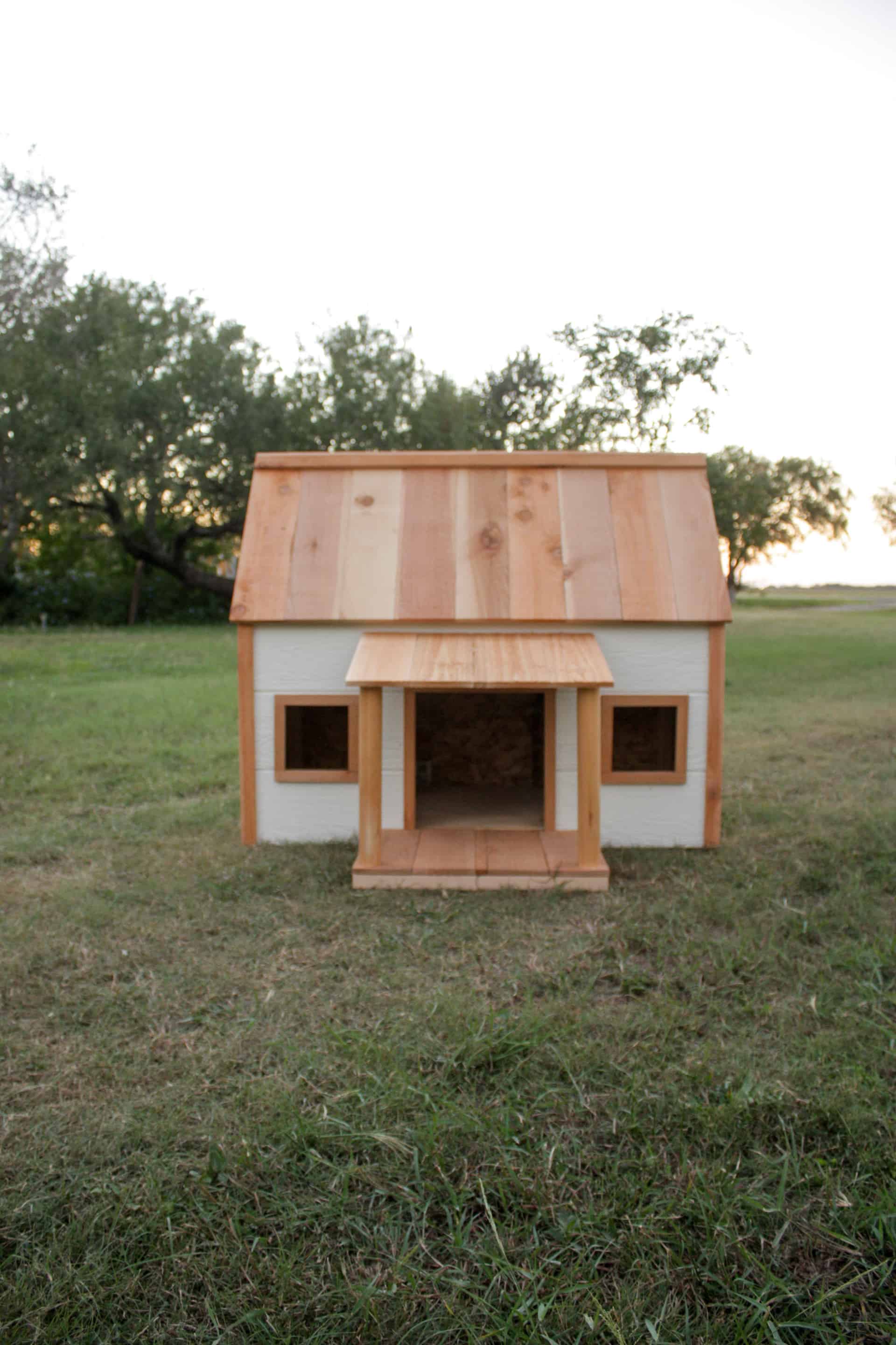 DIY Doghouse with Porch front view in a grassy area