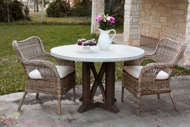 Round Concrete Outdoor Dining Table with wicker chairs