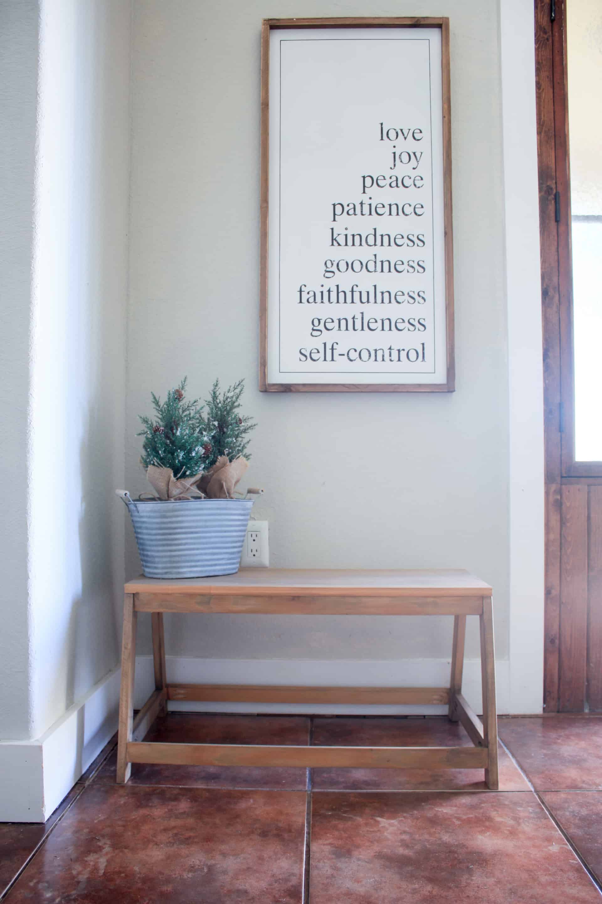 DIY Small Modern Bench with fruits of the spirit sign above it and small christmas trees in a galvanized bucket