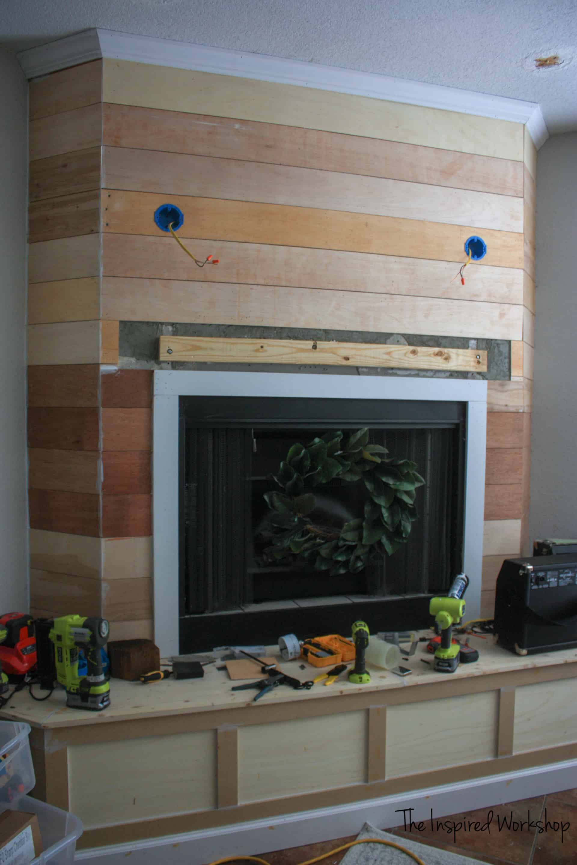 Hanging the mantel with all the shiplap in place and the light boxes in with electrical wires hanging