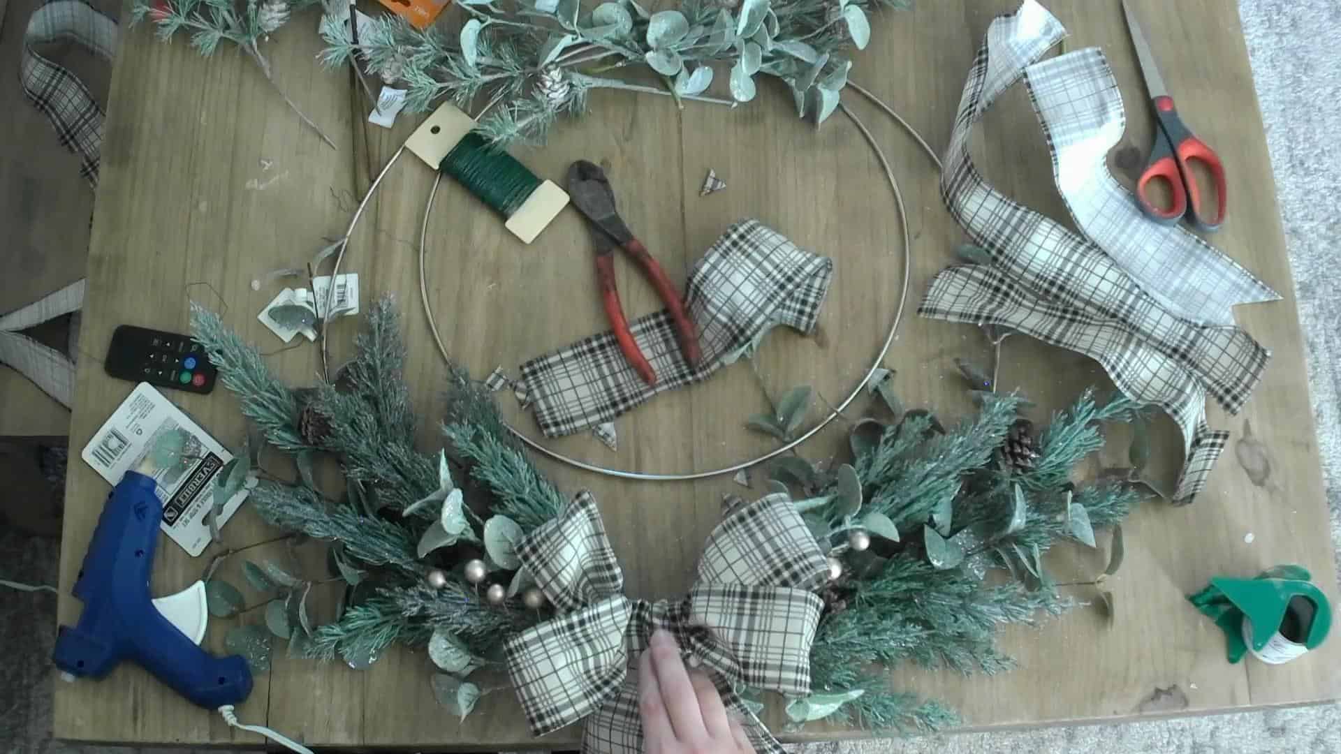 Attaching the bow to the DIY Christmas wreath