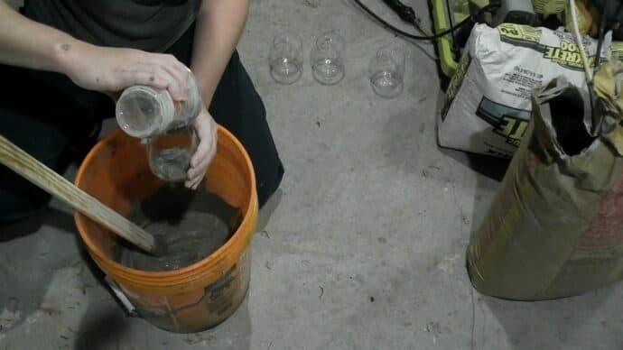 pouring the concrete into the wine glasses for the gnome bodies