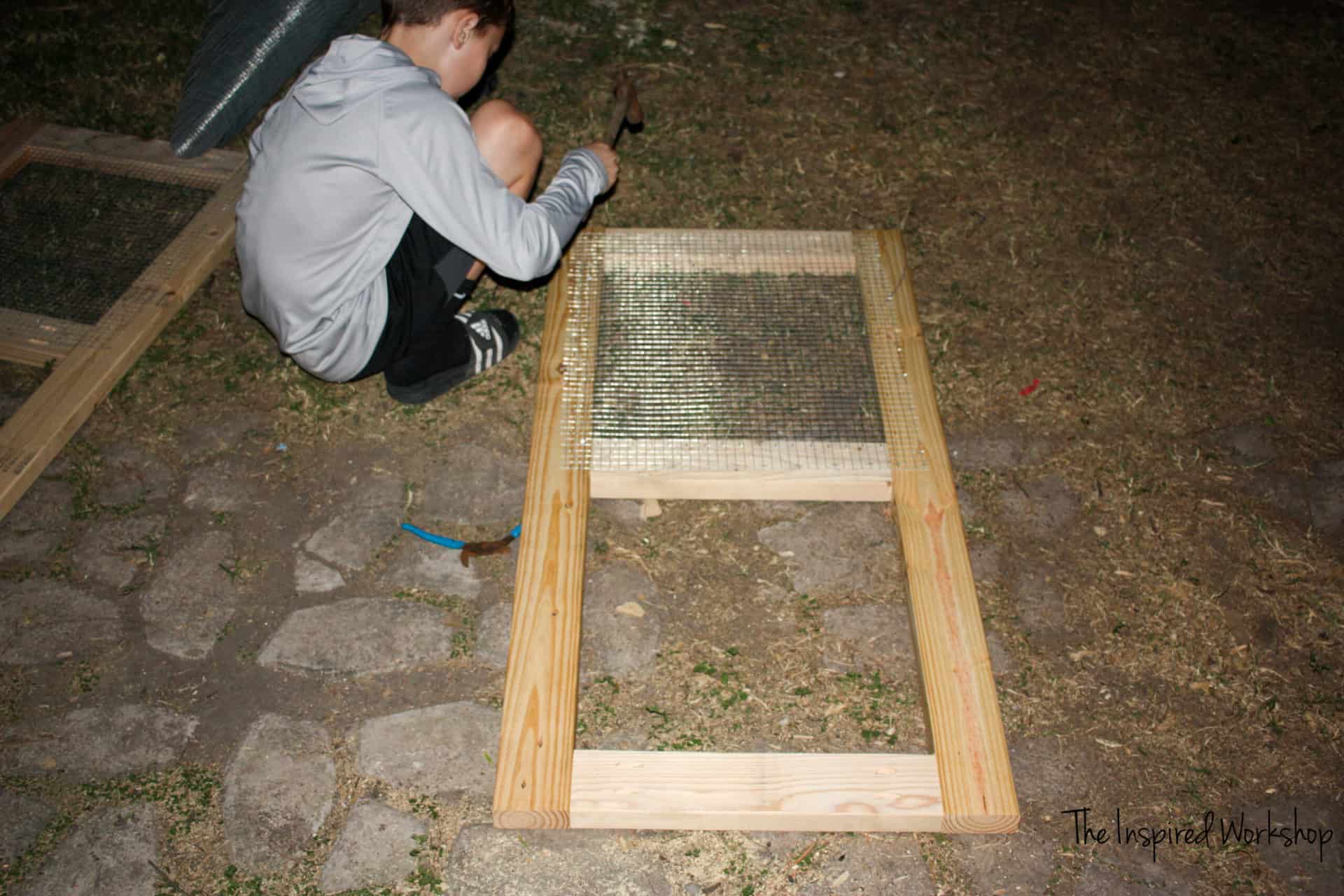 DIY Chicken Coop - boys helping attach hardware cloth