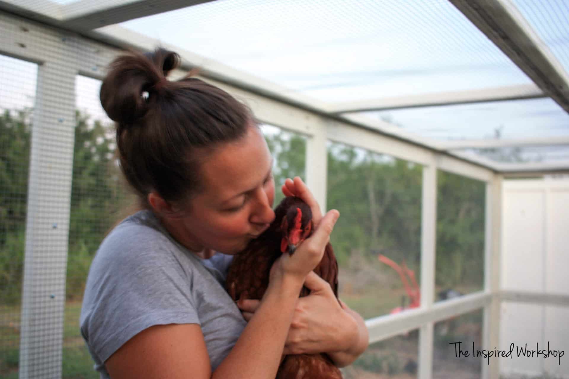 Me kissing my chicken inside the chicken coop run!