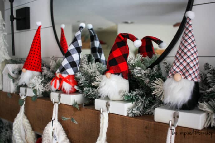 Concrete Gnome Stocking Holders - four gnomes on the mantel with red and black hats