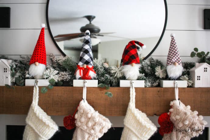 DIY Gnome Stocking Holders four gnomes on the mantel holding stockings