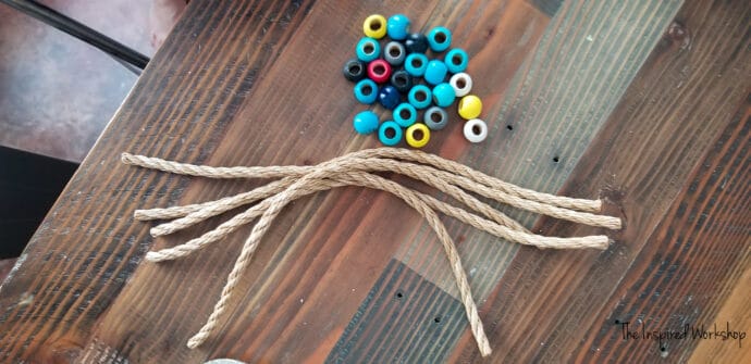 Rope and wooden beads laying on the table to make ring toss rings