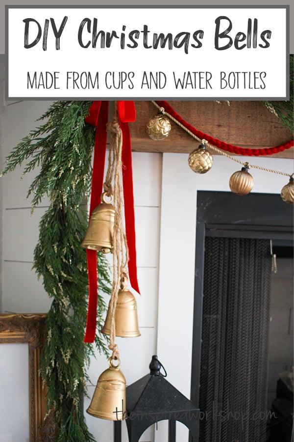 Christmas Bells hanging over the edge of the fireplace with garland and red velvet ribbon