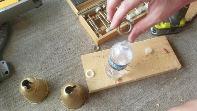 showing the hole I drilled in a water bottle lid to make the ring on the Christmas bells