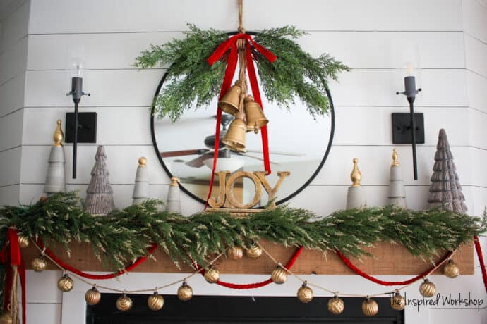 DIY Christmas bells hanging on the mirror over the fireplace with a gold and red Christmas theme