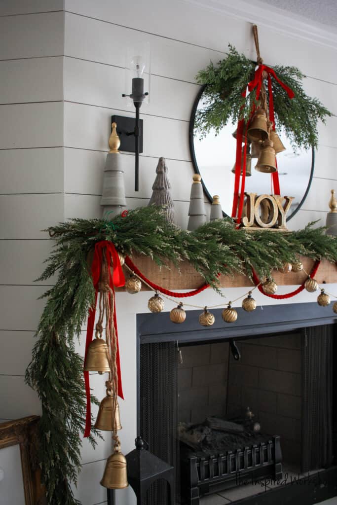 DIY Christmas Bells adorning the fireplace mantel and wreath on the mirror