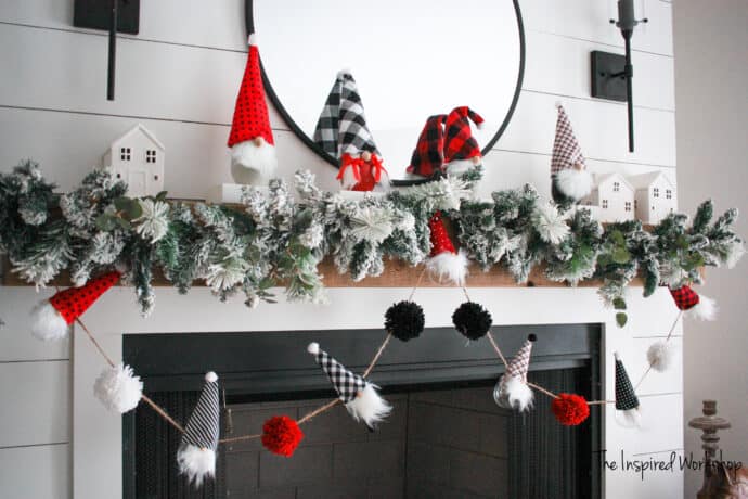 DIY Christmas Gnome Garland adorning the fireplace with gnome stocking holders and red and black themed