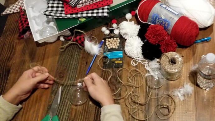 Tying the ornament onto the diy christmas garland