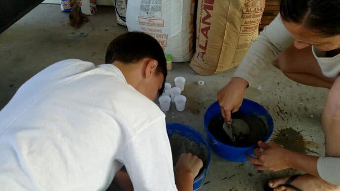 mixing the concrete into cups for the christmas trees