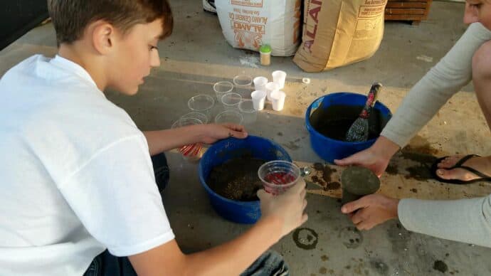 tapping the cup of concrete to get the air bubbles out