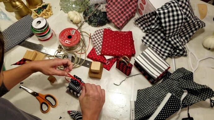 Tying the tibbon on the stacked gift boxes to make the ornament