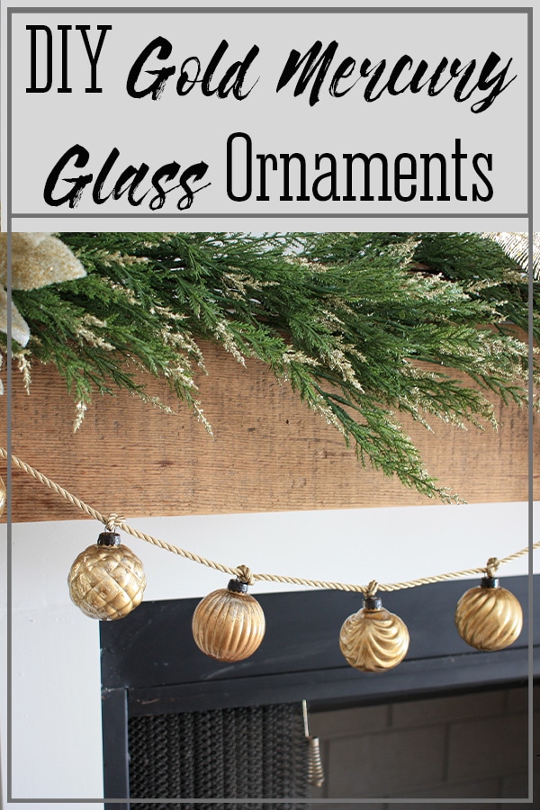 Beautiful faux gold mercury glass ornaments on garland hanging on fireplace mantel