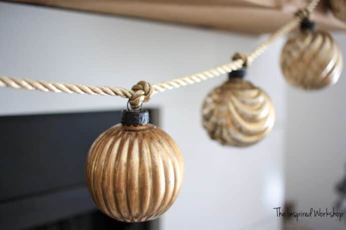 gold Mercury glass ornaments made into a garland hanging from a gold rope ribbon