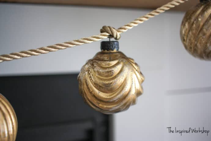 DIY Gold Mercury Glass Ornaments hanging from a gold rope