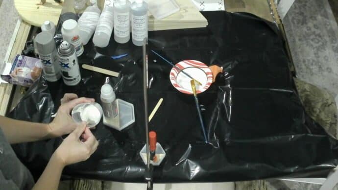 mixing the white paint into the epoxy so we can make the faux marble side of the coasters