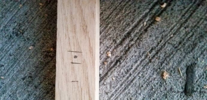 marked board for dowel holes to be drilled