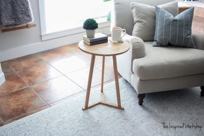 DIY Small Round Side Table with a couple books and a small plant with a cup of coffee on it