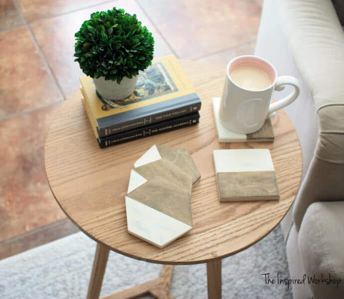 DIY marble epoxy resin coasters made with wood and epoxy setting on a small round table with coffee