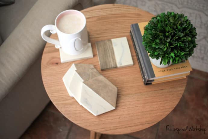 Wood and epoxy coasters sitting in a spread stack in a small round table with books and coffee