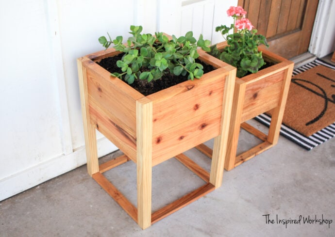 Planter boxes on the front porch two different sizes by black and white striped rug