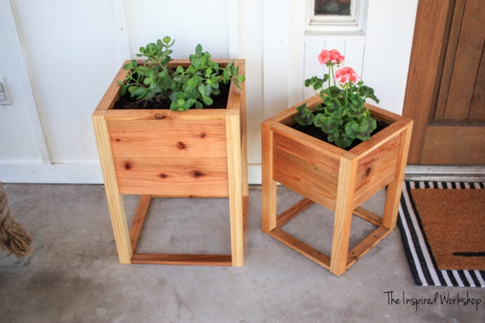 Planter boxes on the proch by the front door, one large one smaller with plants in them