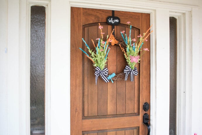 Spring wreath with wild flowers butterflies and a dragonfly