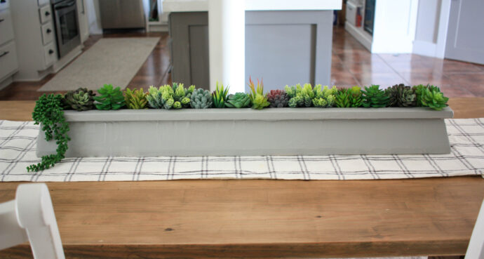 Succulent table centerpiece on a plaid table runner