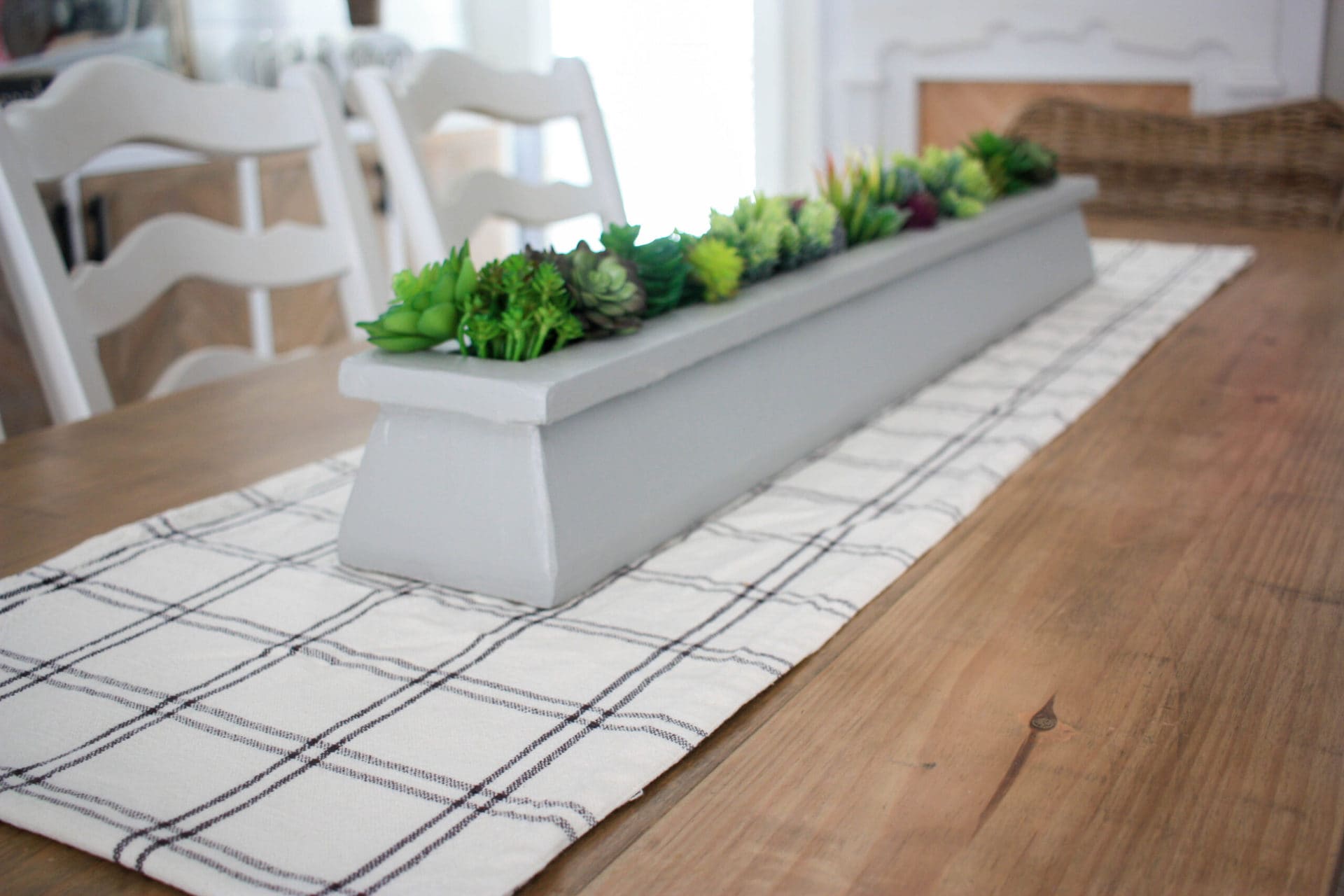 DIY table centerpiece on the table with succulents and a black and white plaid table runner