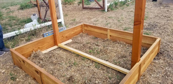 attaching the trellis to the garden planter before dirt is added