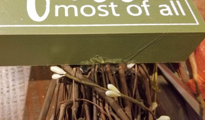 showing the hot glue on the fall sign for the fall wreath