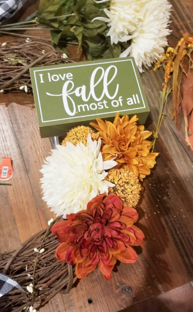 adding all the flowers to the DIY fall wreath