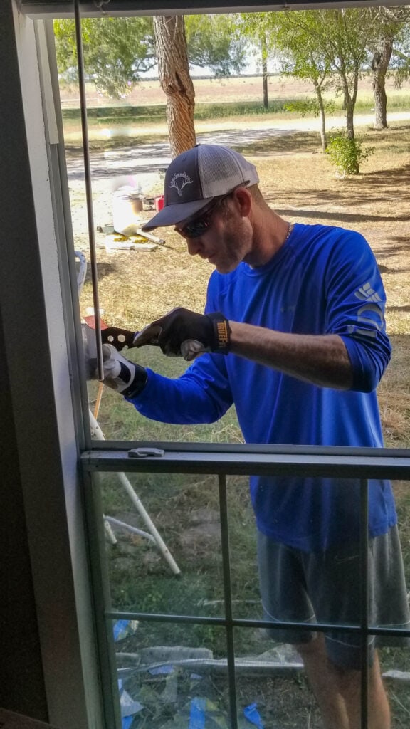 cleaning the silicone from the window frame to replace the window glass