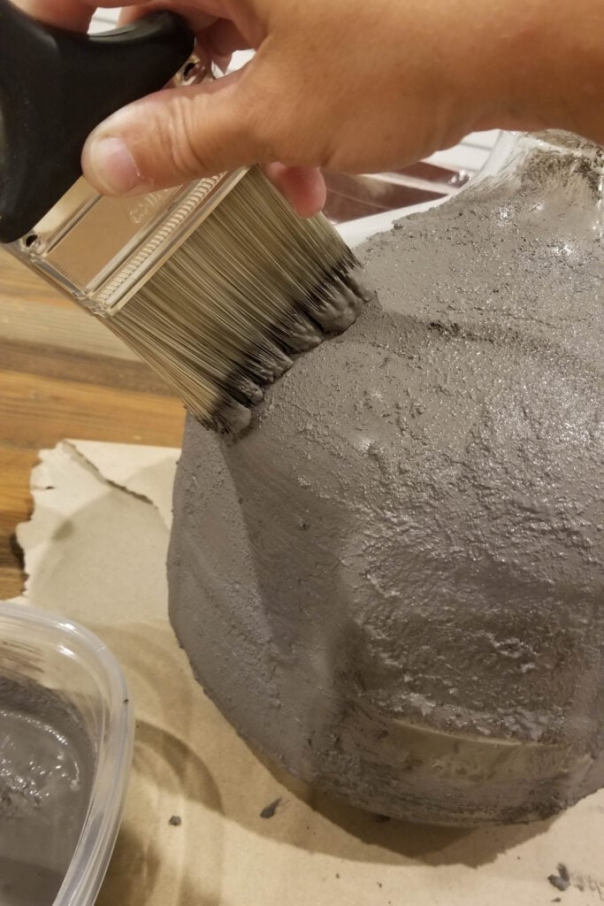 dabbing paint with baking soda to make glass vase look like a stone vase