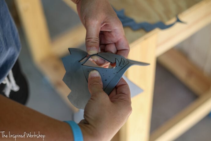 peeling the stamp away from the sheet of rubber