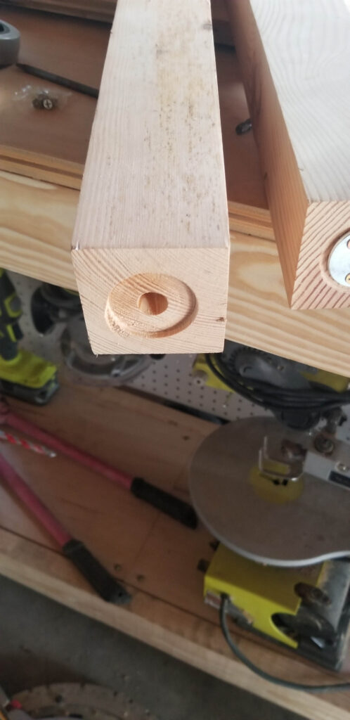 drilling the holes in the bathroom vanity leg to attach the furniture feet