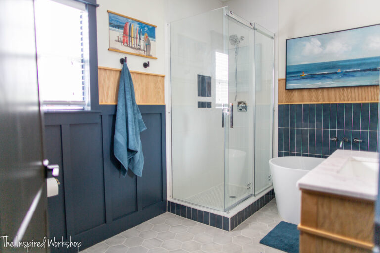 Bathroom Remodel with glass shower enclosure and a navy blue and white theme with wood accents