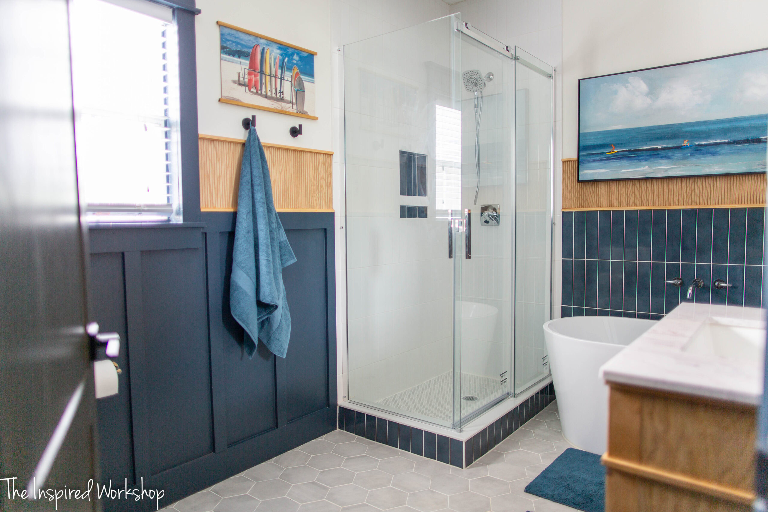Bathroom Remodel with glass shower enclosure and a navy blue and white theme with wood accents