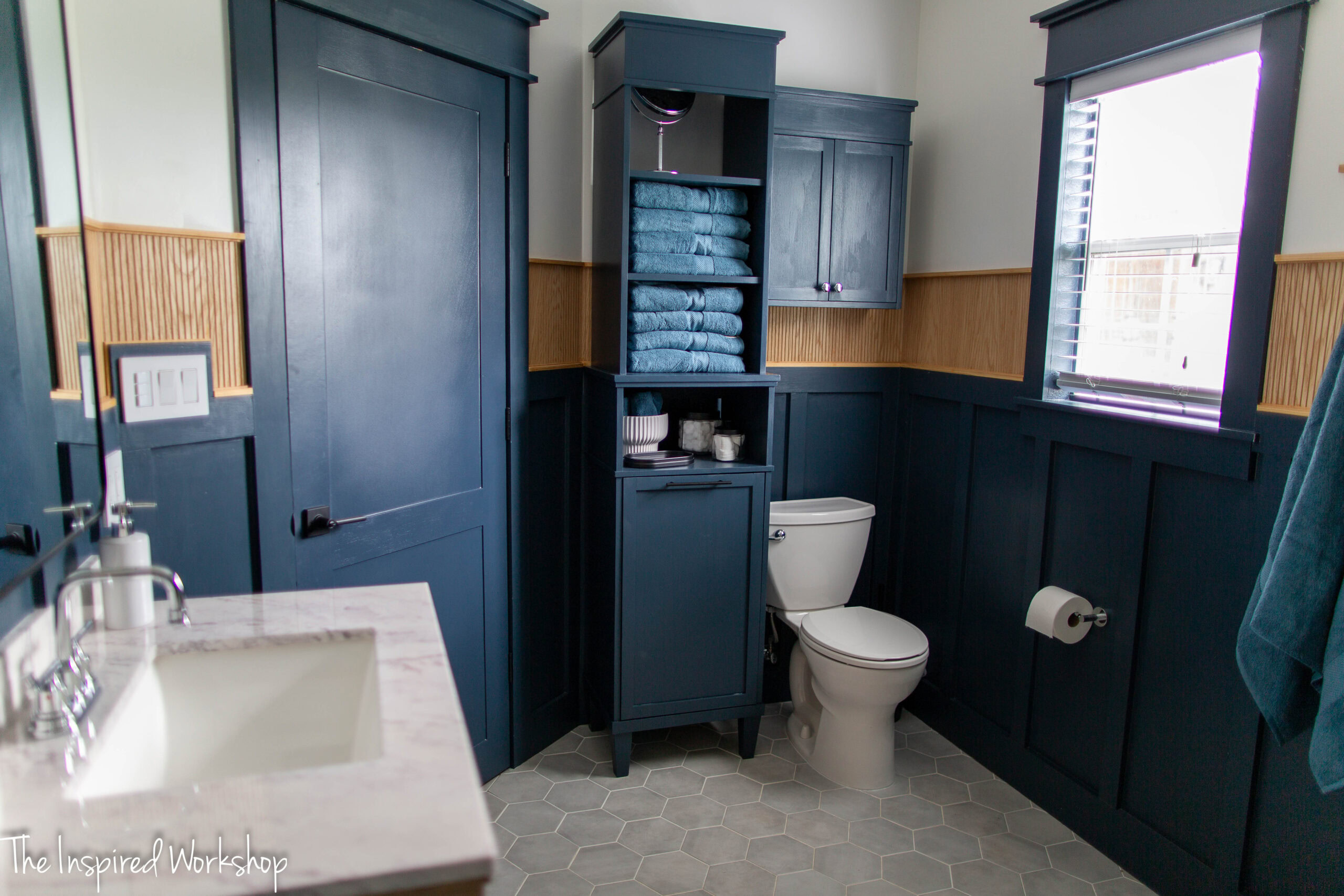 linen cabinet beside the toilet and a cabinet hanging above the toilet