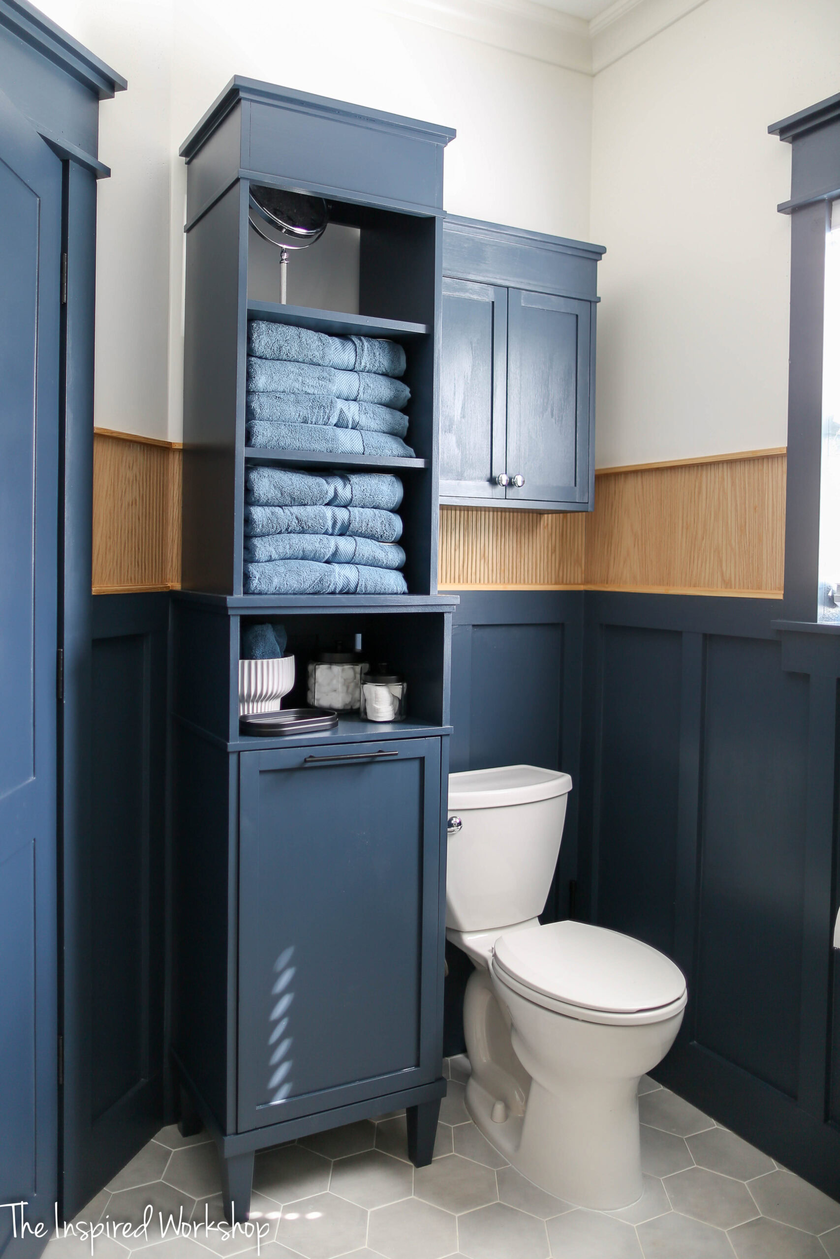 linen cabinet beside toilet with towels on the shelves