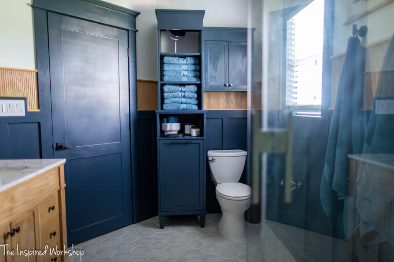 bathroom view of the toilet and laundry hamper and toilet cabinet