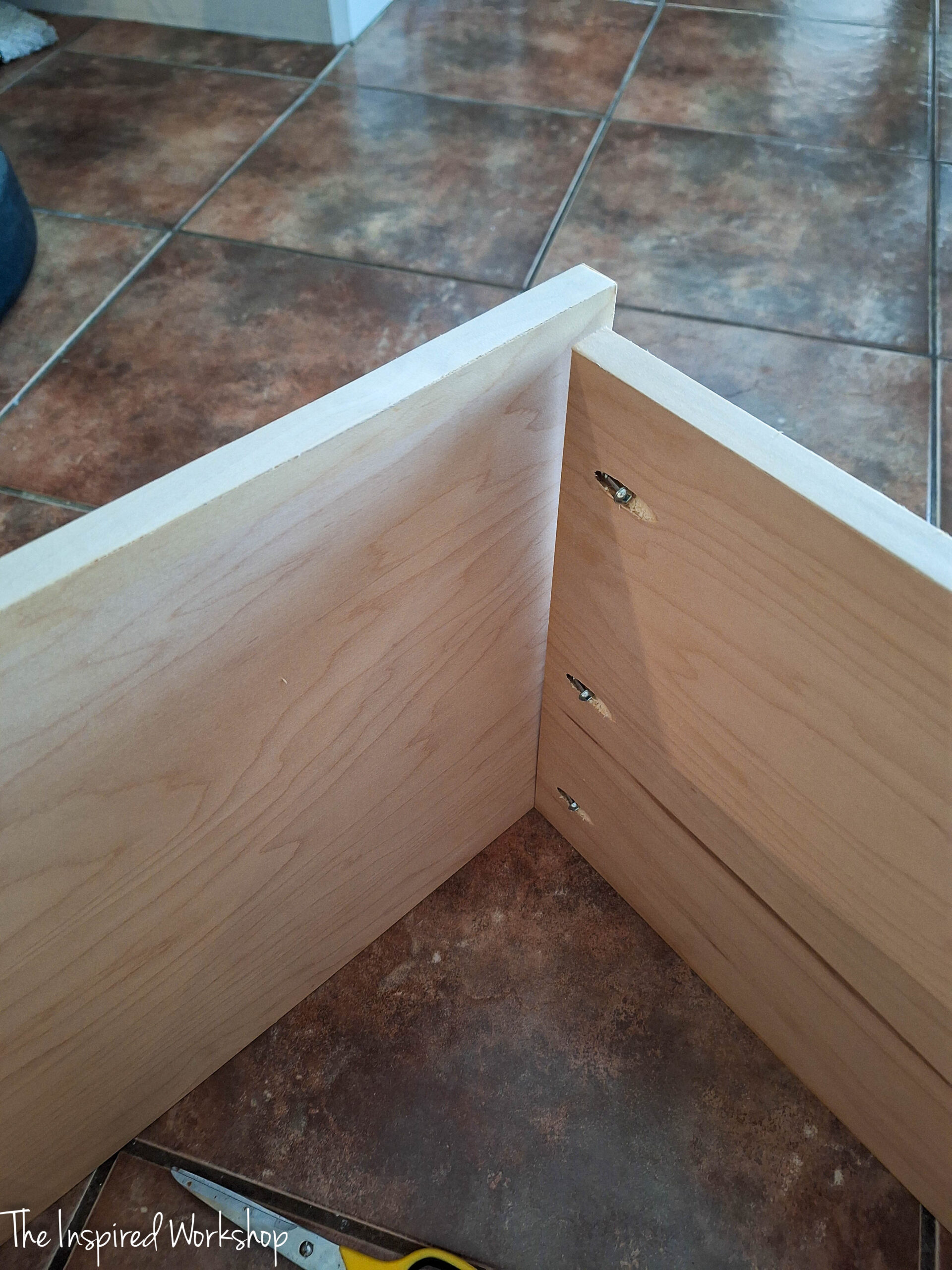 top of the base of the linen cabinet showing the pocket holes from the sides into the top board